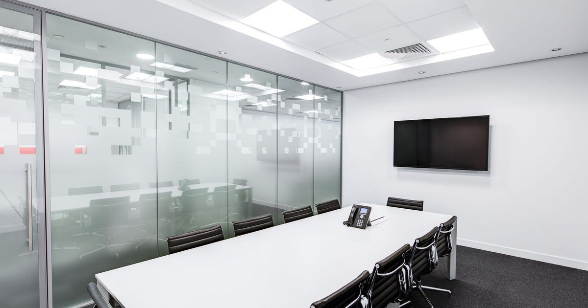 Sala de reuniones vacía con mesa larga y sillas
