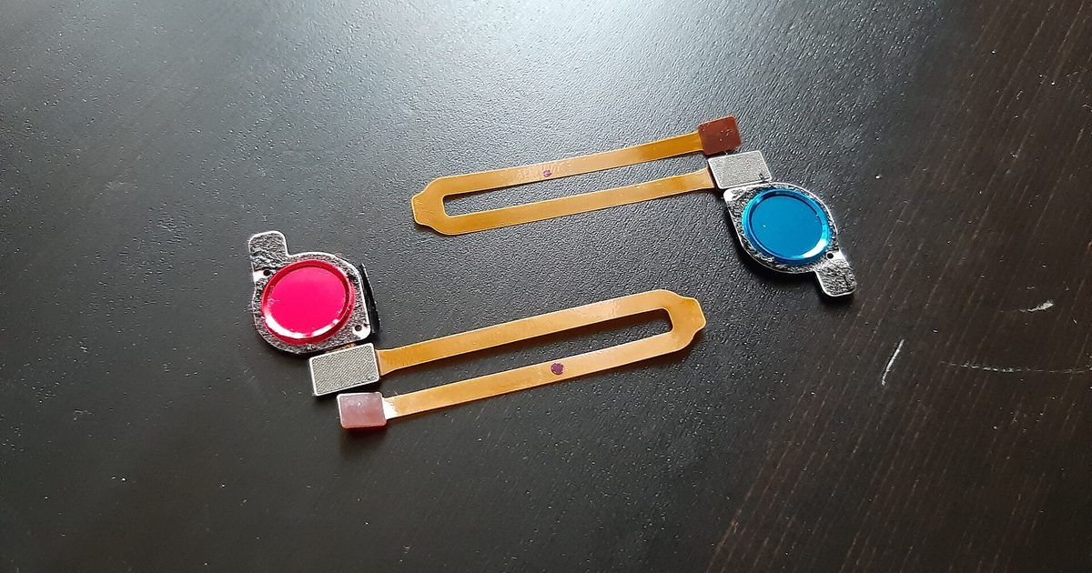 Dos sensores de huella dactilar con su cable flexible sobre una mesa oscura