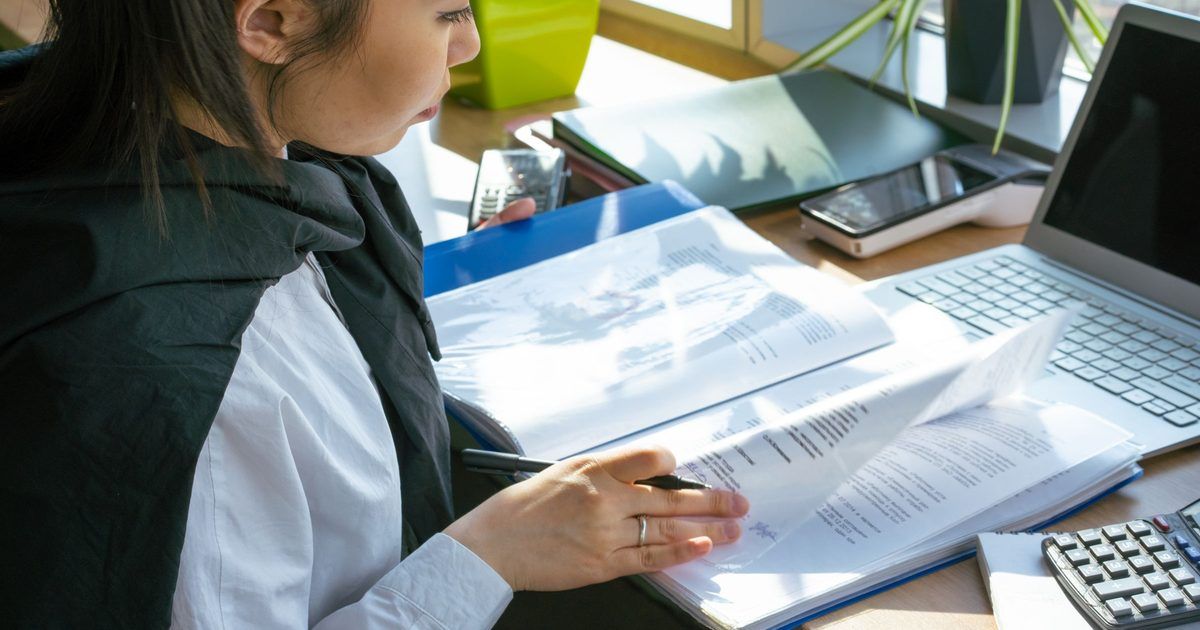 Persona revisando documentos legales frente a un computador