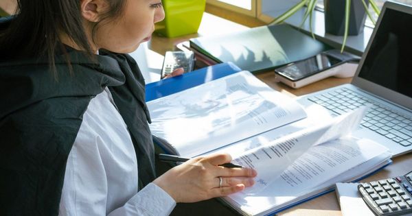 Persona revisando documentos legales frente a un computador
